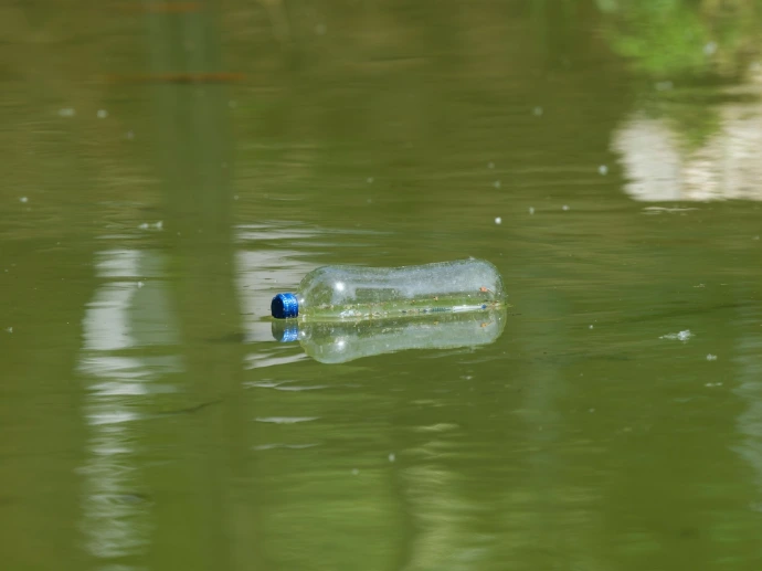 Plastic bottle floating on murky water